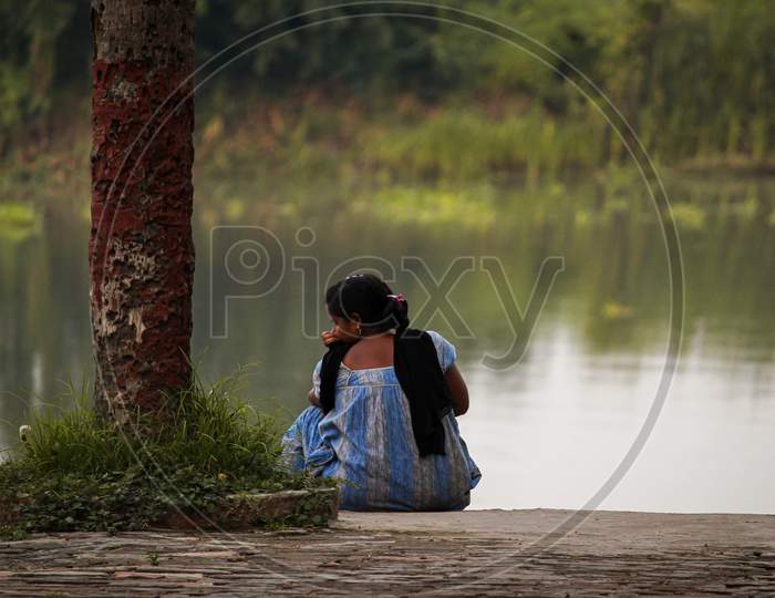 A Lonely Women Sitting Depressingly Near A River