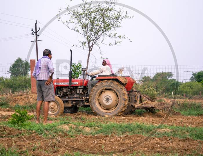 Farmers ploughing their lands using a tractor to prepare it for kharif crops during monsoon or after rain in Rajasthan