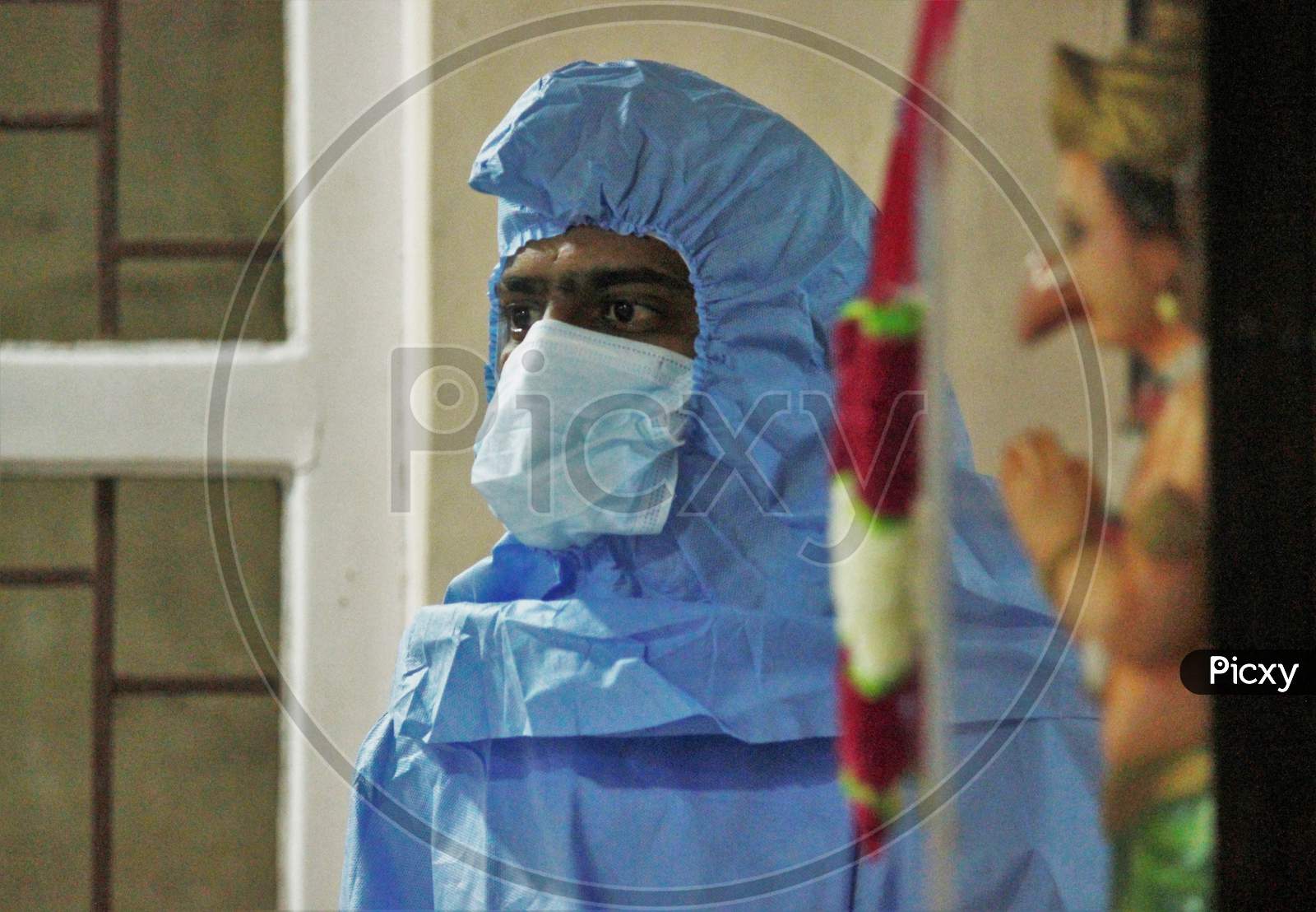 A Healthcare worker wearing a Personal Protective Equipment (PPE) waits to screen people at a camp set up for the coronavirus disease (COVID-19),inside a temple in  Mumbai, India on July 15, 2020.