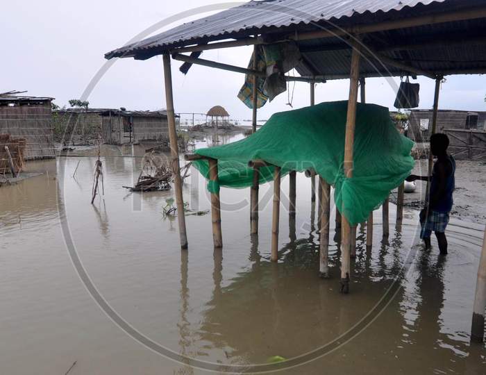 A villager stands in his hut which got damaged due to the flood at Puthimari village in Darrang, Assam on July 21, 2020