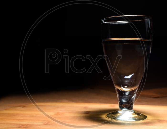 Wine Glass With Wine On Wooden Table With Black Background.