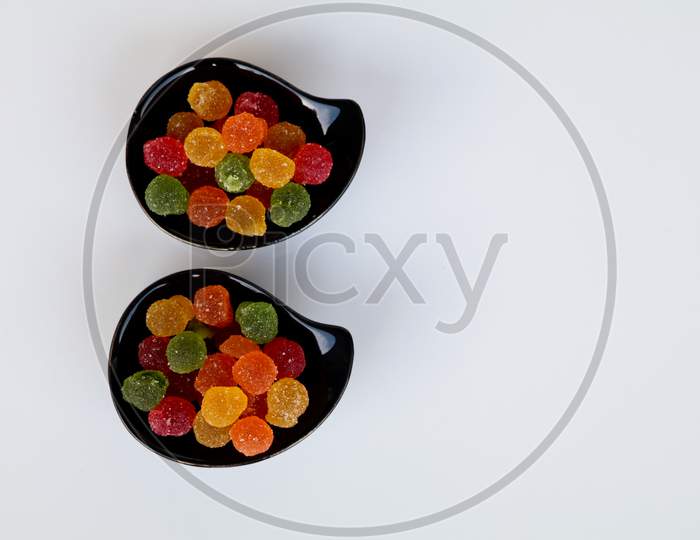 Sweet Mixed Color Jelly Candy In A Black Bowl Against White Background With Copy Space