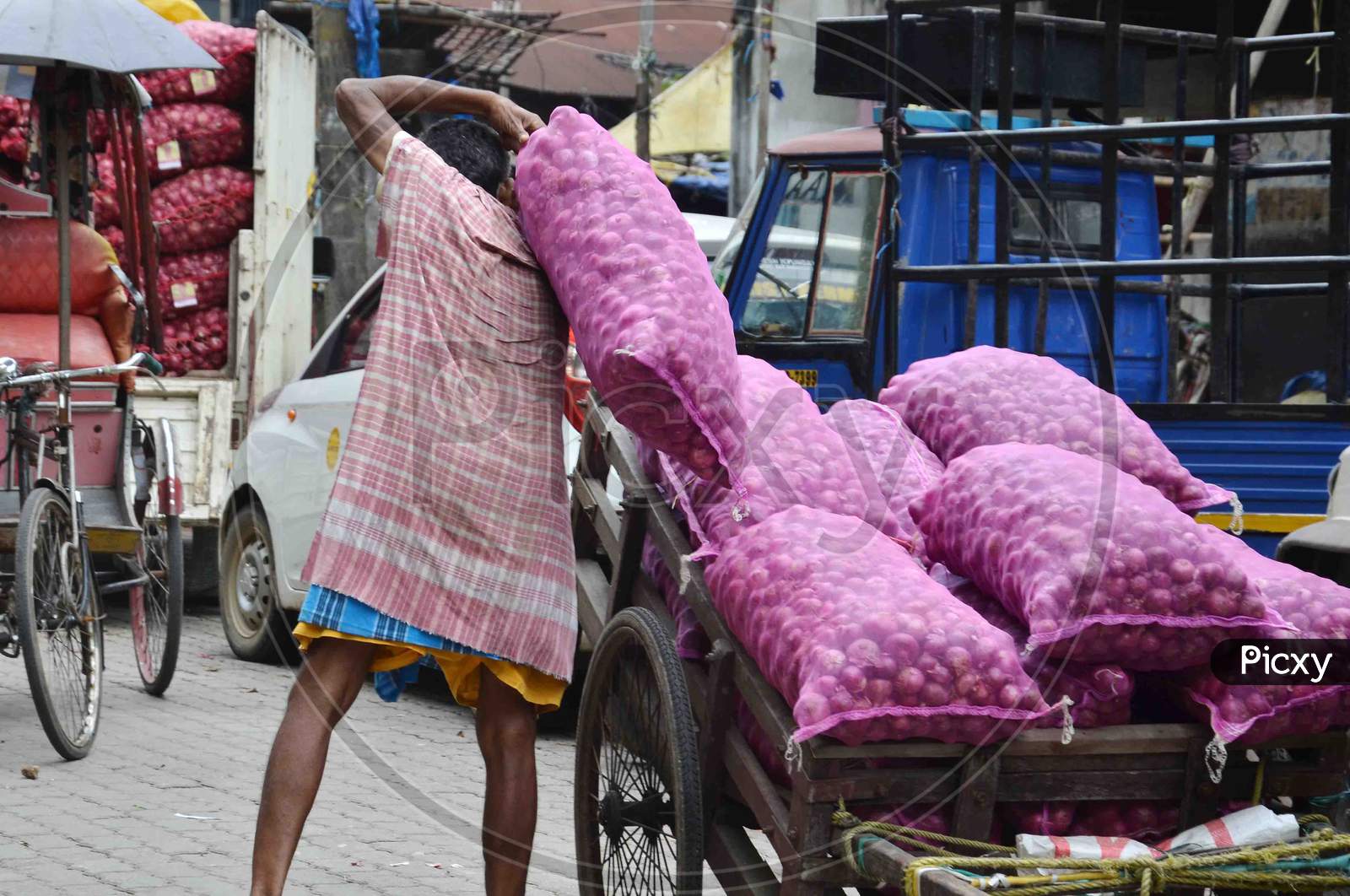 A labour unload a sack of Onion