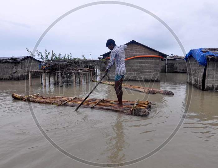 Villagers use a makeshift raft to navigate the floodwaters to reach a safer place in Darrang, Assam  on July 21, 2020