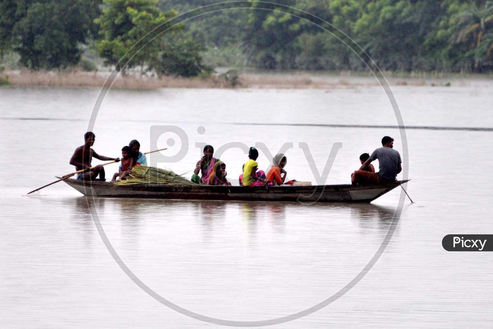 Villagers use a boat to reach a safer place in the flood-affected areas pf Puthimari village in Darrang, Assam on July 21, 2020