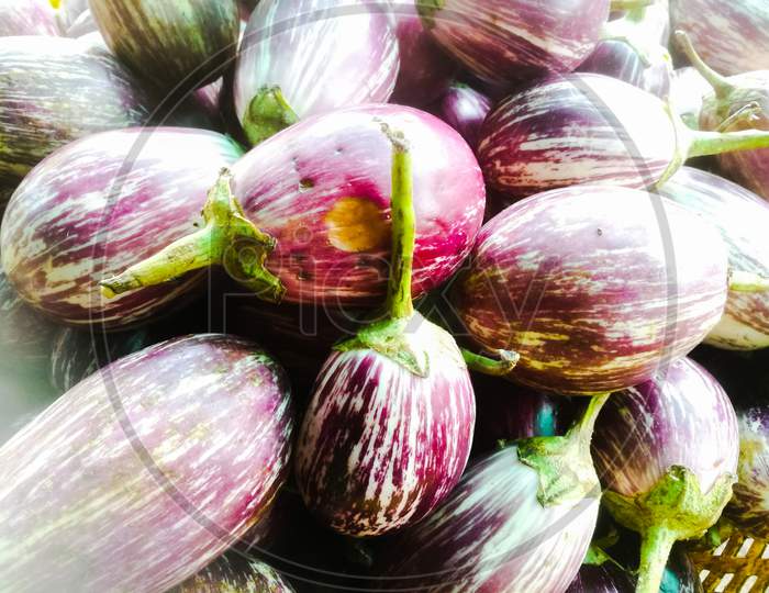 A Closeup Shot Of A Group Of Violet Colored Brinjal In A Basket.