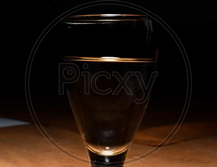 Wine Glass With Wine On Wooden Table With Black Background.