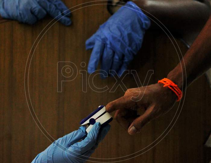 A healthcare worker wearing personal protective equipment (PPE) measures the pulse of a resident  at a camp set up for the coronavirus disease (COVID-19) inside a temple in  Mumbai, India on July 15, 2020.