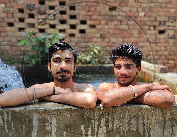 Two child, bathing in village pool.