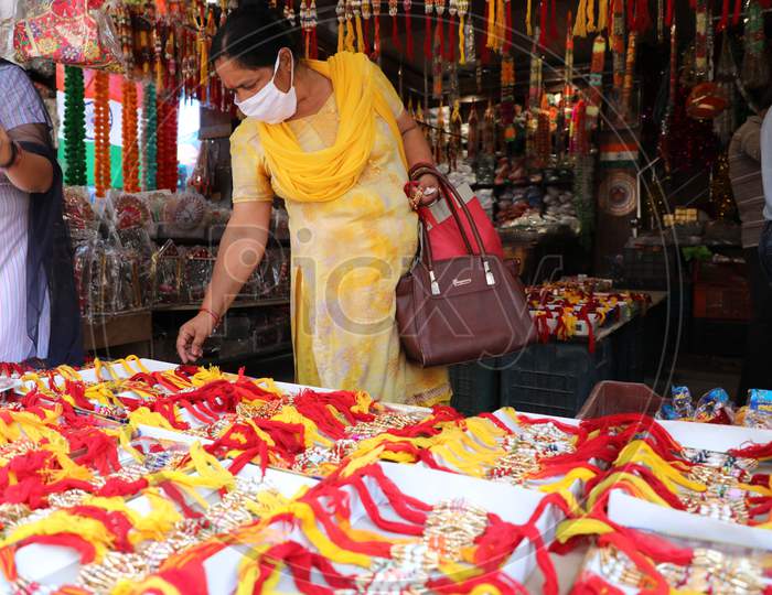 A woman buys rakhi, a bracelet made of thread ahead of the Raksha Bandhan, a festival which celebrates the bond between brothers and sisters in Jammu on July 22, 2020