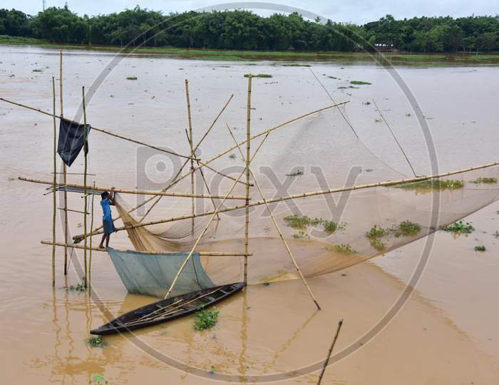 A villager fishes in floodwaters in a flood-affected village in Nagaon, Assam on July 22, 2020