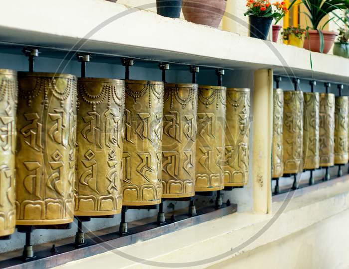 Religious Copper Buddhist Prayer Wheels With A Prayer Mantra Written On It In A Pilgamage Spot In A Monastary