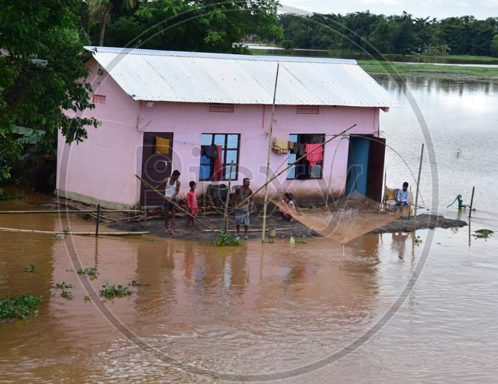 A man uses his fishing nets to catch fishes in the floodwaters near his partially submerged hut at a village in Nagaon, Assam on July 22, 2020
