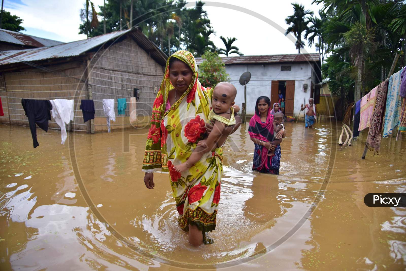 Two women wade through floodwaters in a flood-affected village in Nagaon, Assam on July 22, 2020