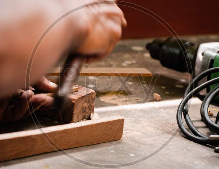 A Mechanic Does Carpenter Jobs With Wood, Saw, Hammer, Nail, Plus And Other Tools
