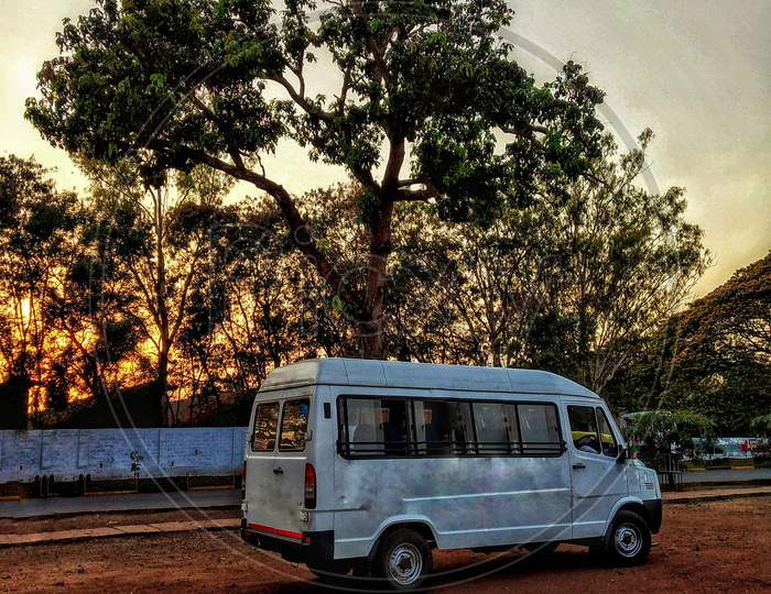 A Mini Bus Parked Under A Tree.