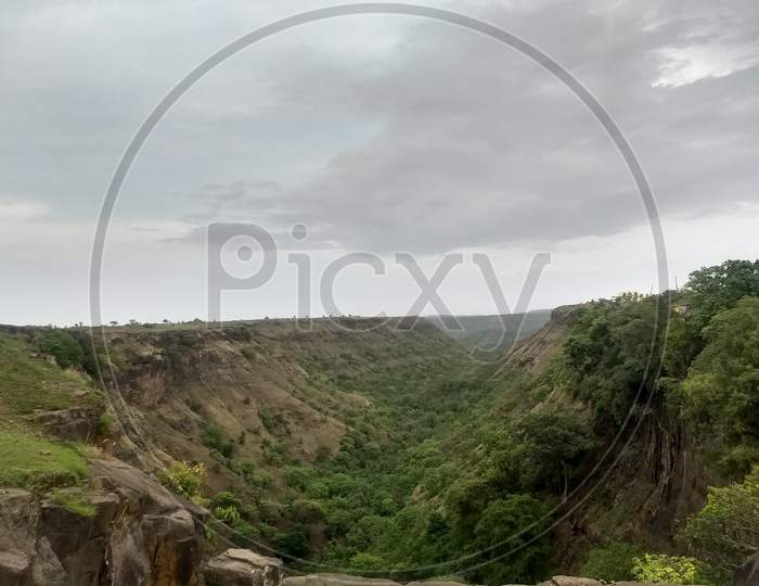 View of a beautiful mountain valley with greenery under clear sky.