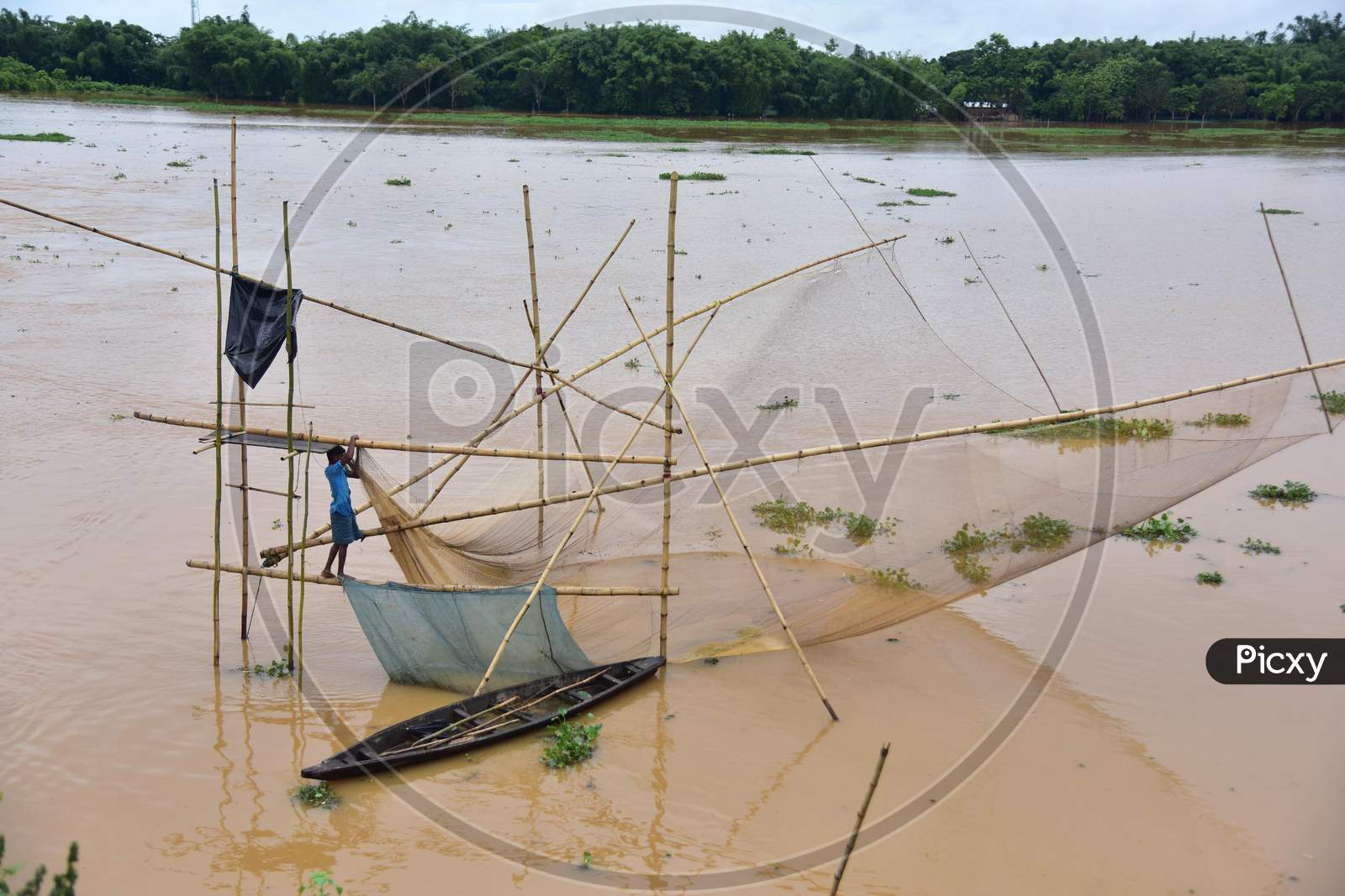 A villager fishes in floodwaters in a flood-affected village in Nagaon, Assam on July 22, 2020