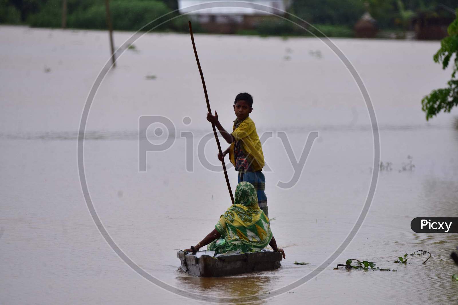 A child uses a makeshift boat to reach a safer place in the flood-affected village in Nagaon, Assam on July 22, 2020