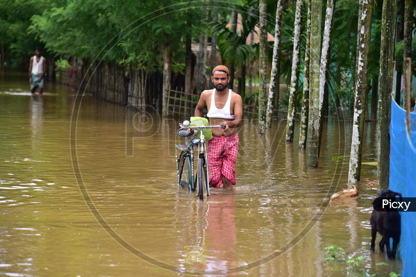 A man wades his way through flooded waters in a flood-affected area in Nagaon, Assam on July 22, 2020