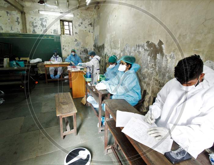 Heathcare workers wait for the recovered covid-19 patients, during screening for plasma donation, at a camp set inside a classroom of a school, at Dharavi, in Mumbai, India on July 23, 2020.