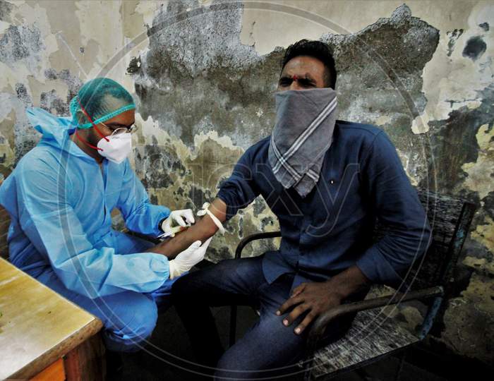 A healthcare worker collects blood samples from recovered Covid-19 patients during screening for plasma donation, at a camp set inside a classroom of a school, at Dharavi, in Mumbai, India on July 23, 2020.