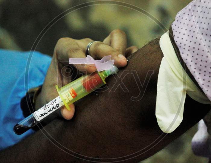 A healthcare worker collects blood samples from recovered Covid-19 patients during screening for plasma donation, at a camp set inside a classroom of a school, at Dharavi, in Mumbai, India on July 23, 2020.