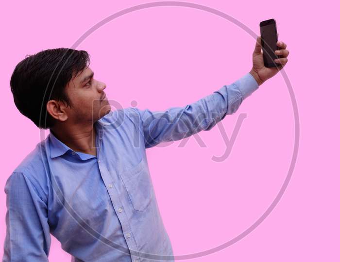 Man taking selfie on mobile isolated on pink background