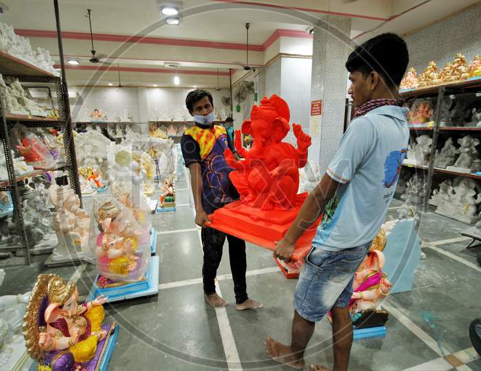People carry an idol of Hindu god Ganesh, the deity of prosperity, before the Ganesh Chaturthi festival, at a workshop in Mumbai, India, July 23, 2020.