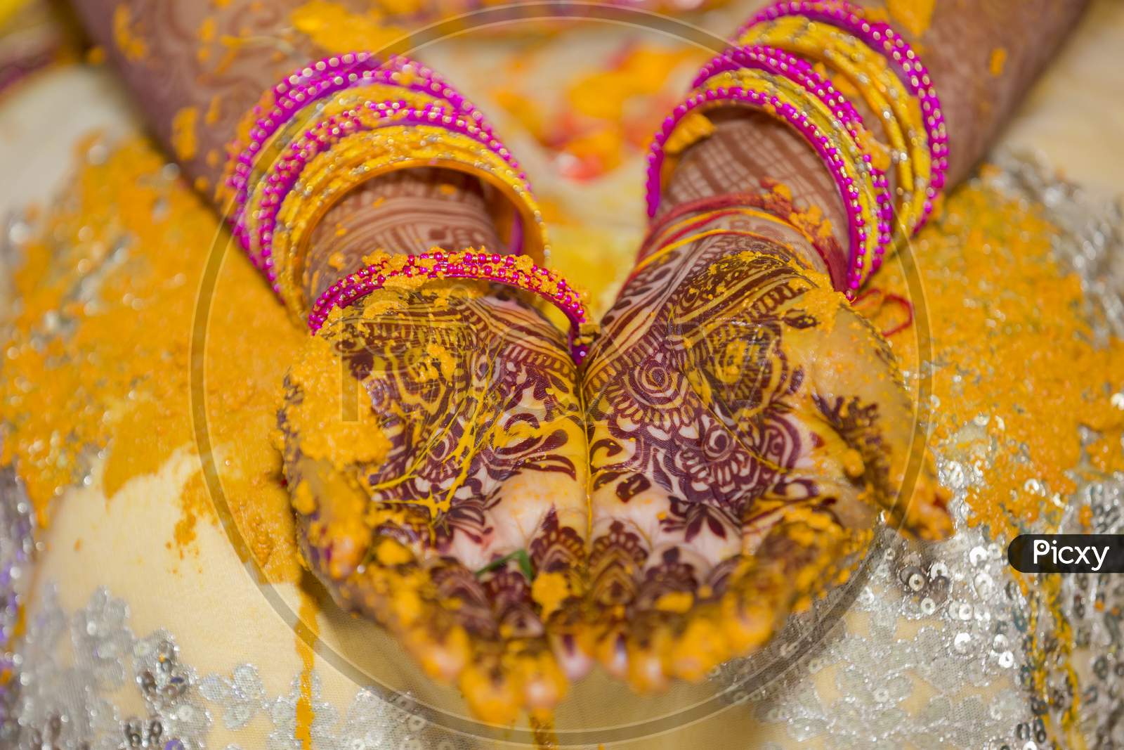 bride's hand painted with fresh turmeric paste.