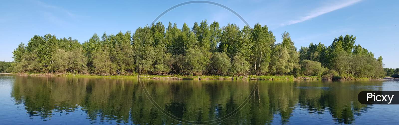 Beautiful Scenery Of A Range Of Green Trees Reflecting In The Lake