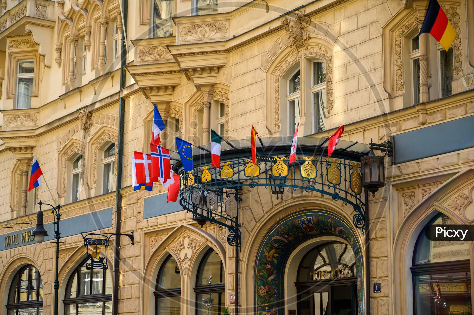 National Flags Above The Entrance To An Old Hotel Building In Prague, Czech Republic