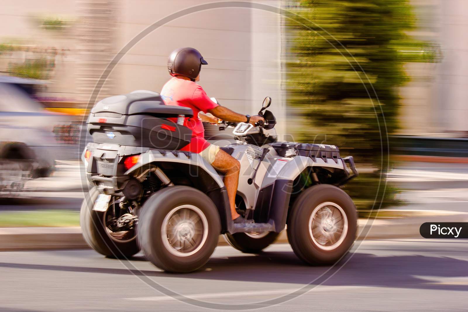 Malaga, Spain - September 04, 2015: Side View Of A Man Wearing Helmet And Riding Quadro Four Wheel Scooter Aka Quooder In Costa Del Sol