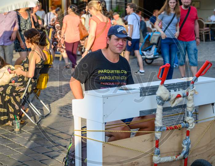 A Male Street Performer Sat At A Piano On The Cobbles Of The Old Town Square, Prague, Czech Republic