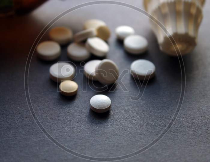 Tablets, pills, medicines and containers display together as medical and pharmacy theme background, selective focus.