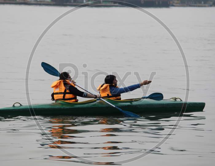 Water background with Two random people with life jacket rowing boat on a evening, at 'Eco Park'