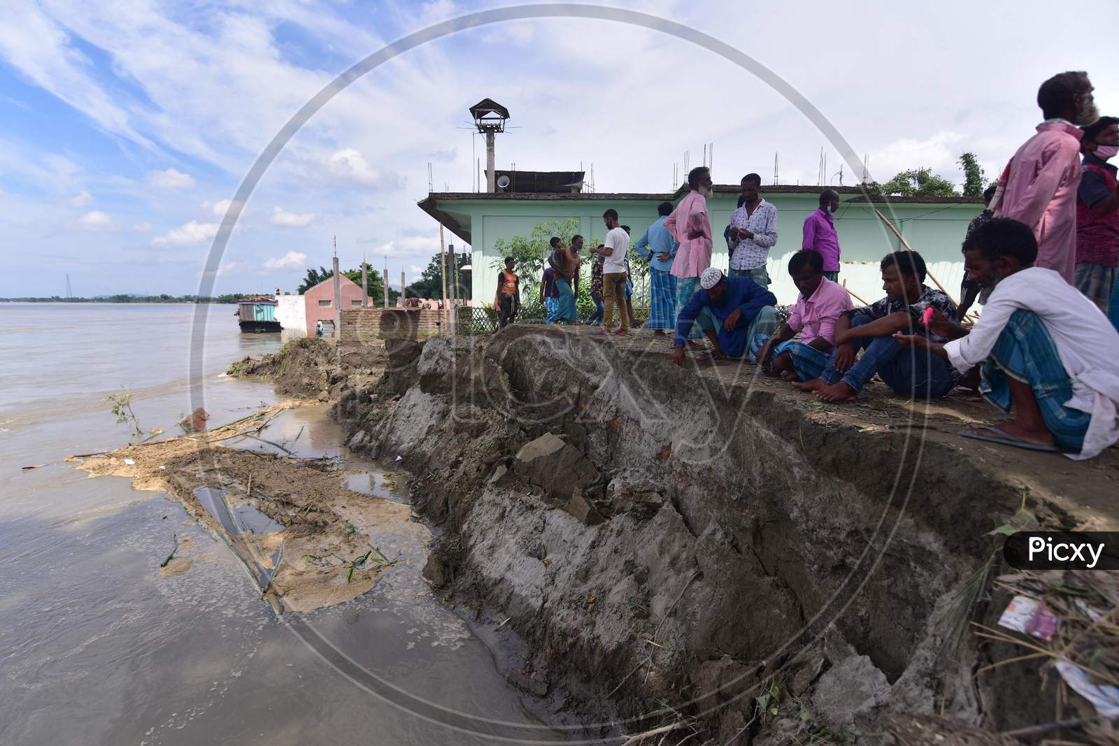 Villagers Stand Next To A School And Mosque That Collapsed On The Banks Of Brahmaputra River Owing To Soil Erosion, At Bhurbandha Village In Nagaon District Of Assam On July 25, 2020.