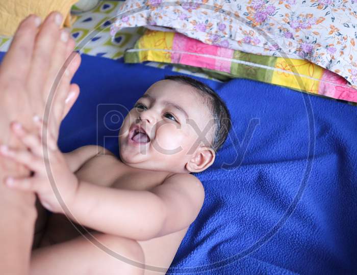 An Infant Toddler Baby Boy Smiling On A Blue Towel