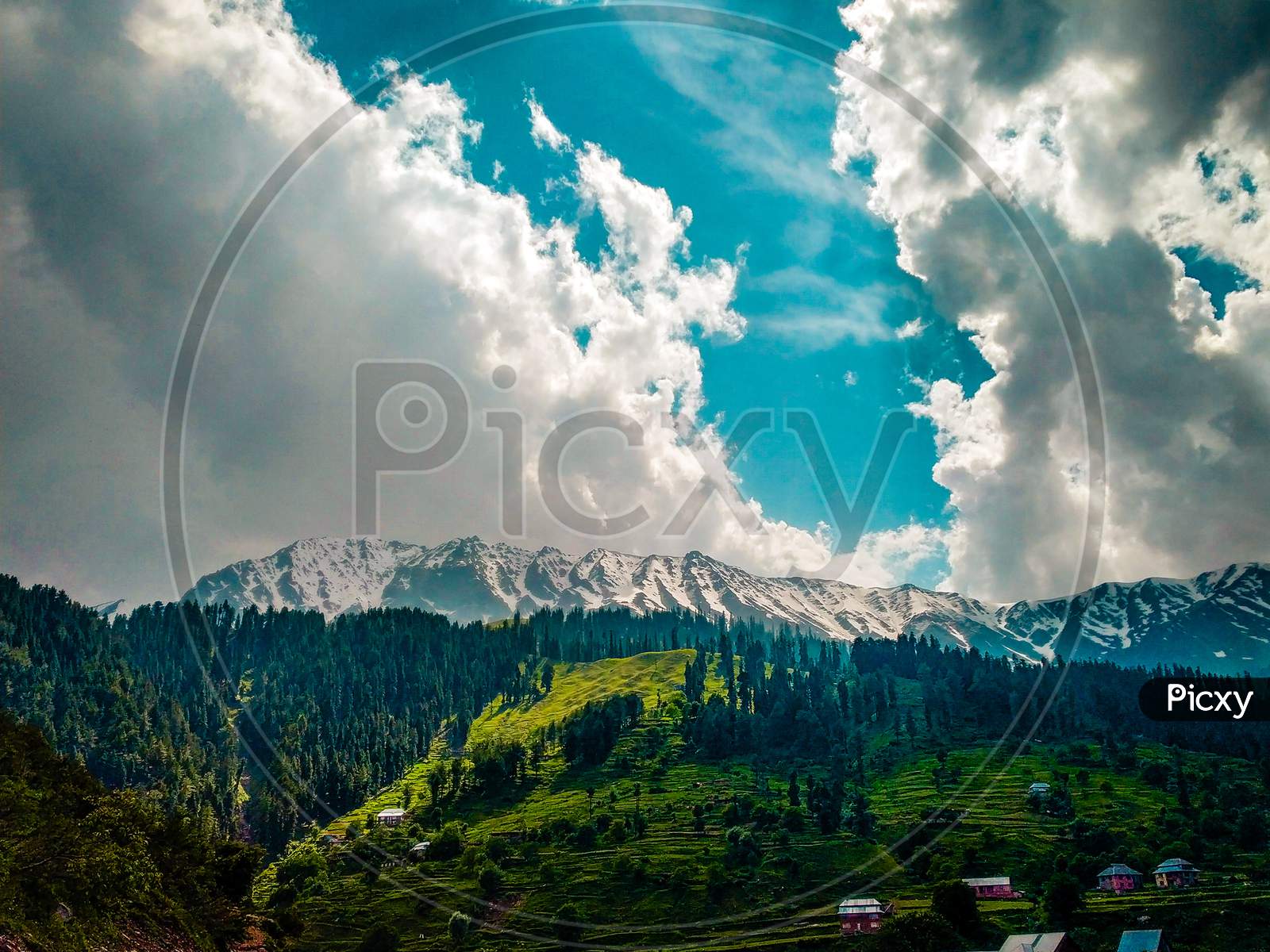 Landscape Of Snow Capped Mountains & The Cloudy Sky