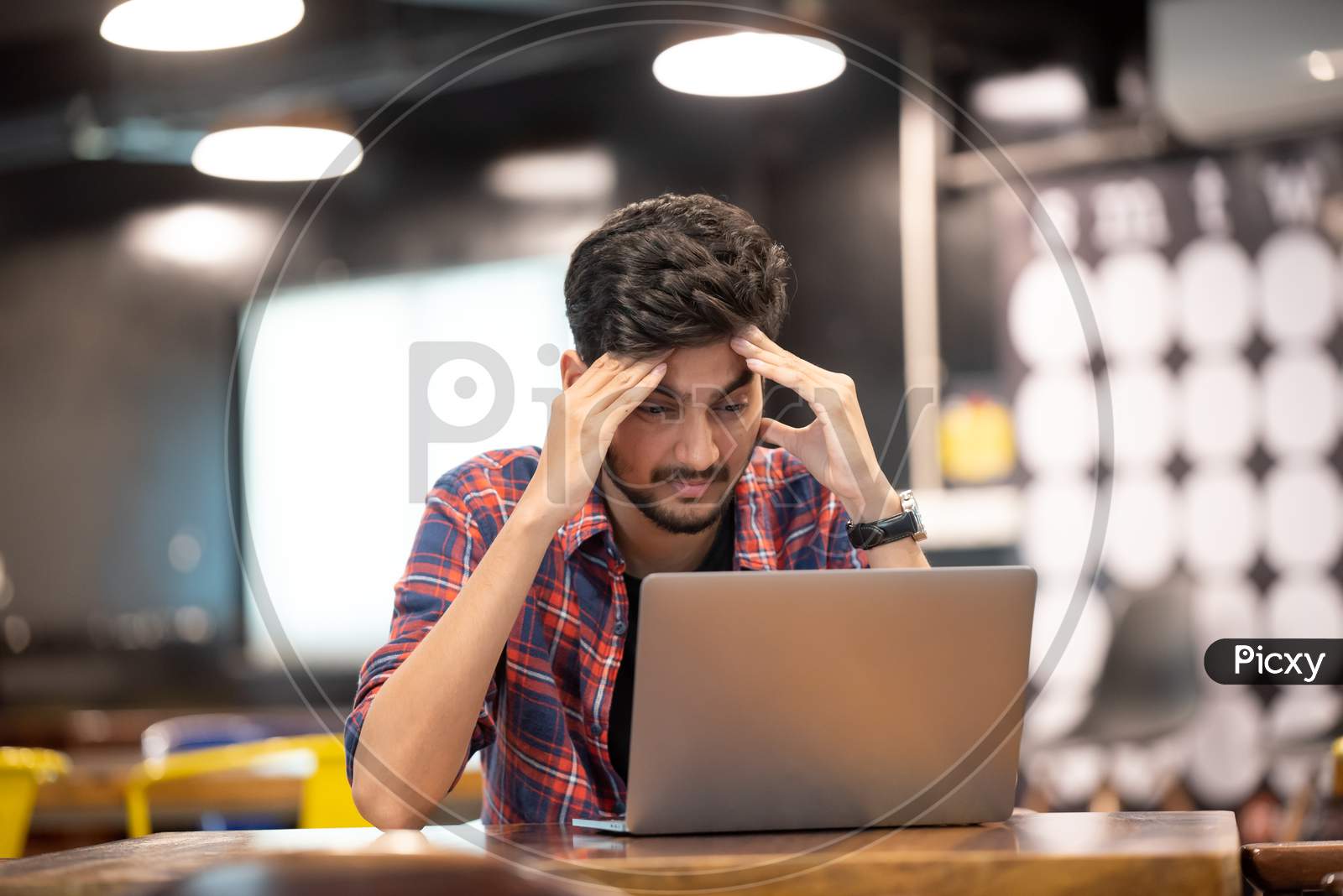 Frustrated Young Indian Man while working on a laptop