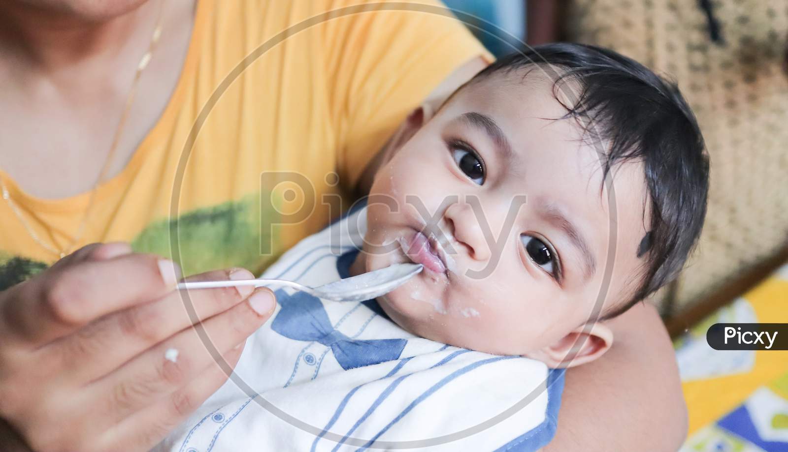 An Infant Toddler Baby Boy After Weaning Eating Solid Food With Spoon