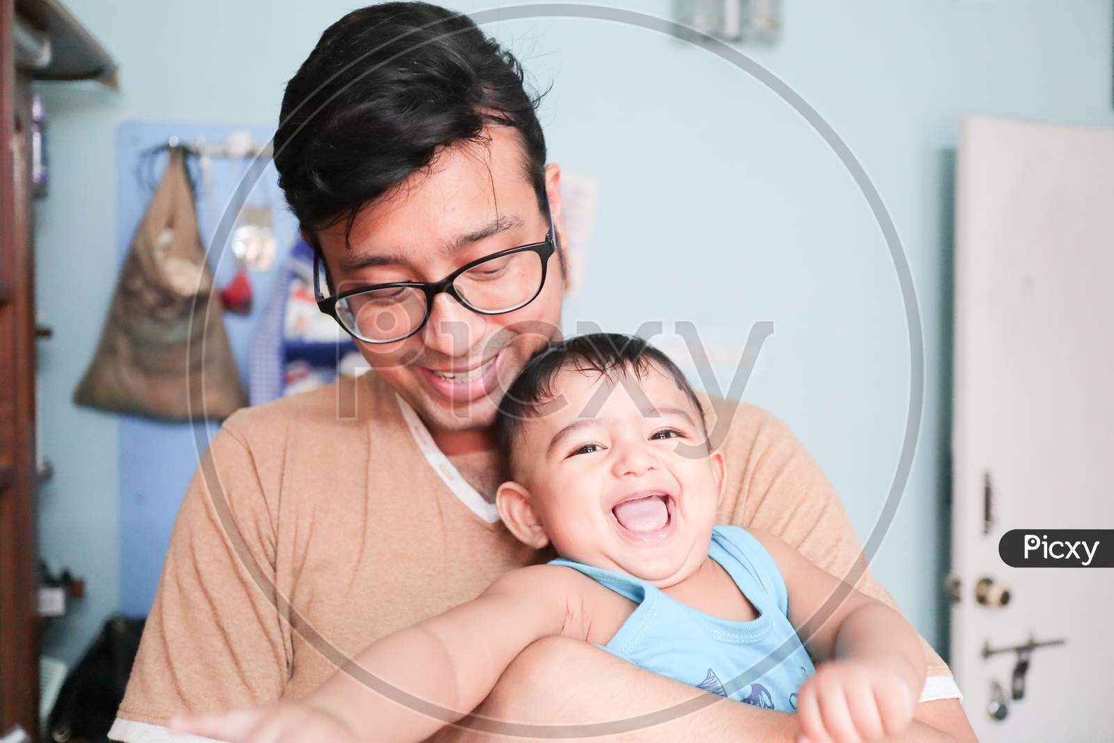 An Infant Toddler Baby Boy Smiling On Father'S Lap