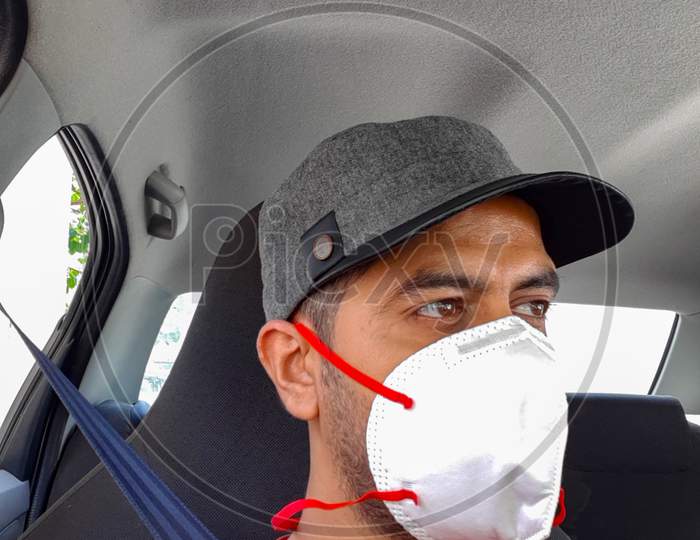 New Delhi India – July 3 2020 : Man in protective mask sitting inside his car amid safety from Coronavirus Covid 19, Mature Man in medical mask for pandemic COVID 19 protection