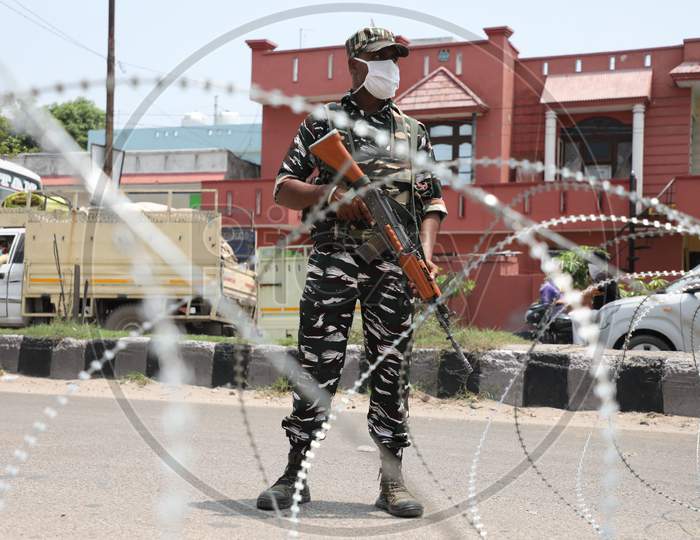 Paramilitary soldiers stand guard outside a containment area as authorities imposed weekend lockdown from 6 pm Friday to 6 am Monday, in Jammu on July 22, 2020.
