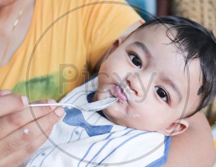 An Infant Toddler Baby Boy After Weaning Eating Solid Food With Spoon