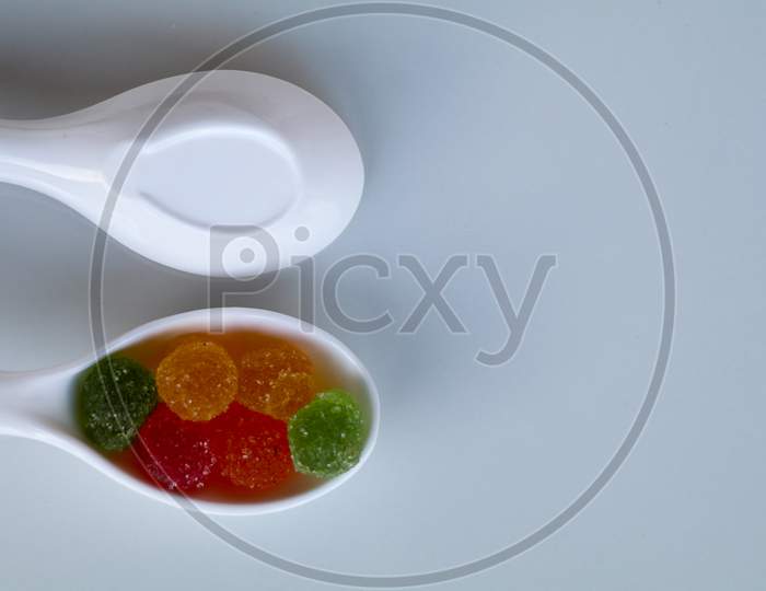Sweet Mixed Color Jelly Candy In A White Spoon Against White Background With Copy Space