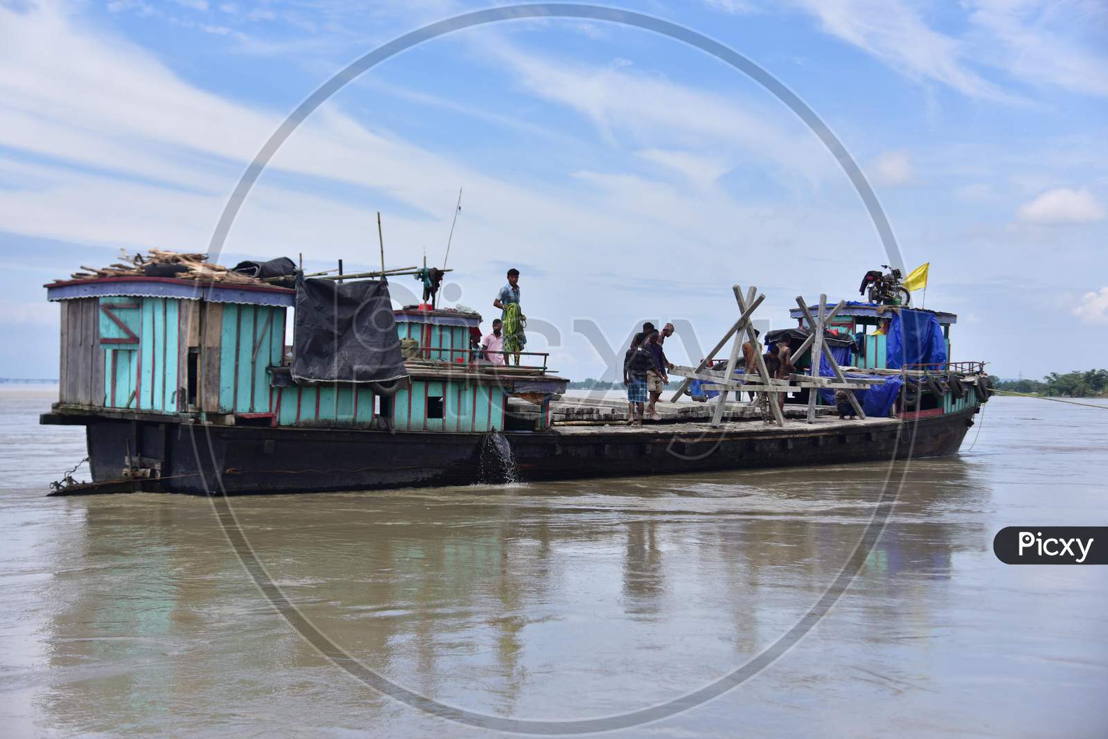 Public Works Department (PWD) Of Assam Labourer Throw Pillars From Boat At The Banks Of Brahmaputra River To Reduce Soil Erosion At Bhurbandha Village, In Nagaon District Of Assam On July 25, 2020.