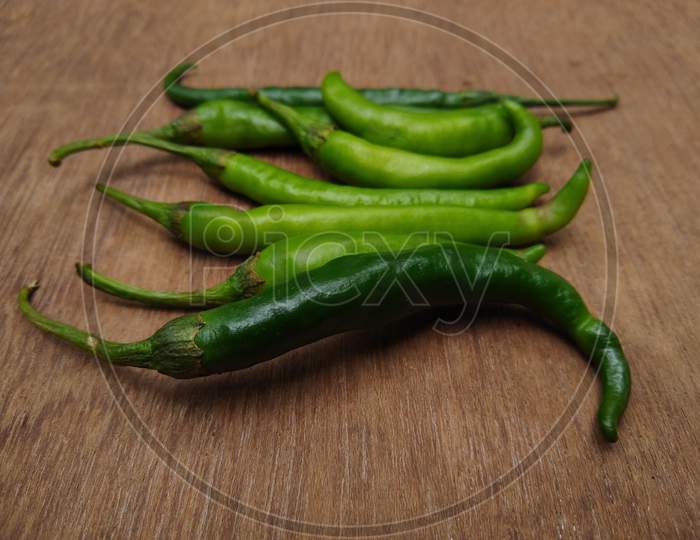 Green chilli peppers on a wooden table