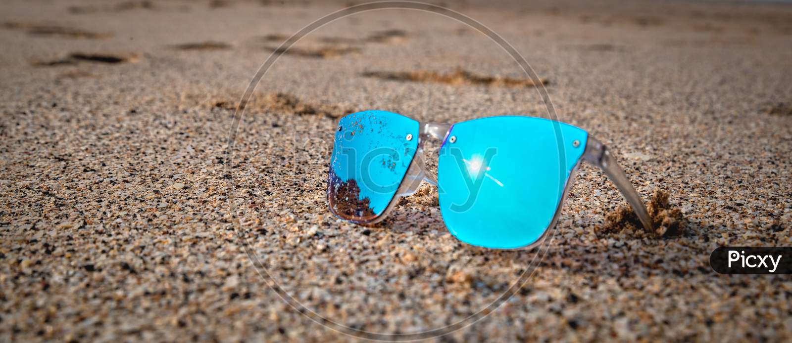 Blue sunglass on beach sand Beach