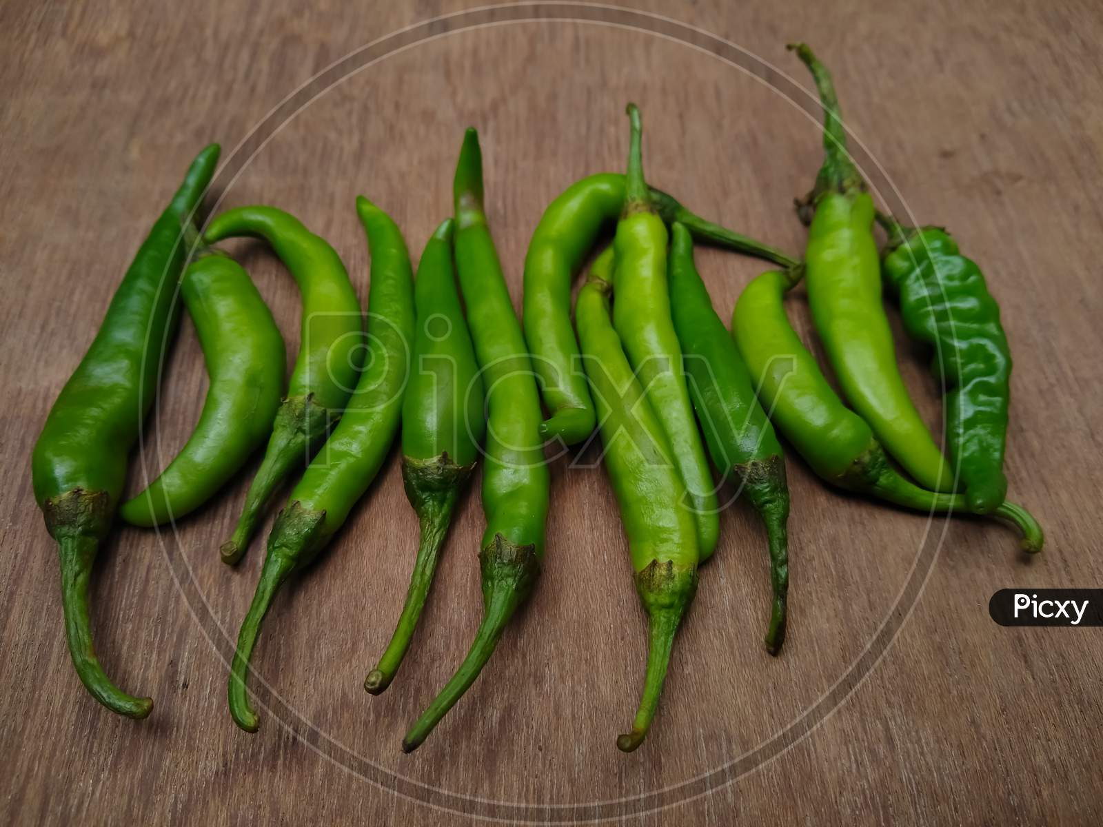 Green chilli peppers on a wooden table